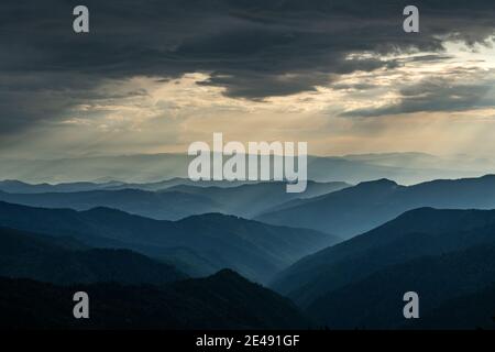 Morgennebel in den Frühlingsbergen. Schöner Sonnenaufgang im Hintergrund. Landschaftsfotografie Stockfoto