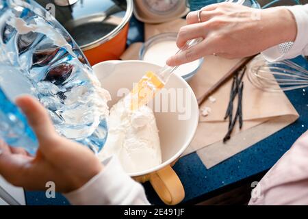 Draufsicht auf eine Frau, die die Zutaten eines mischt Käsekuchen in einer Schüssel Stockfoto