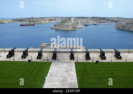 Die Saluting Battery in La Valletta, Malta, vom oberen Barrakka-Garten aus gesehen, mit Meereslandschaft und den drei Städten im Hintergrund Stockfoto