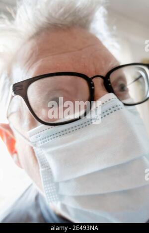 Älterer Mann mit Gesundheits- und Sicherheitsbedenken trägt eine schützende Gesichtsmaske mit beschlagener Brille New York City, USA Stockfoto