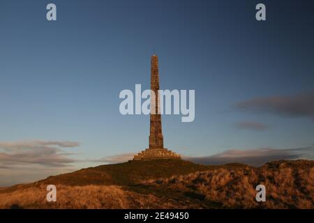 Straiton, Ayrshire, Schottland, Großbritannien. Der Spaziergang und die Aussicht vom Hunter Balir Monument, einem 20m hohen Granitobelisk auf dem Craigengower Hill, der zur Erinnerung an LT-Col James Hunter Blair errichtet wurde, bieten einen Blick auf den Obelisk und Ayrshire, wobei die Sonne im Herbstlicht untergeht Stockfoto