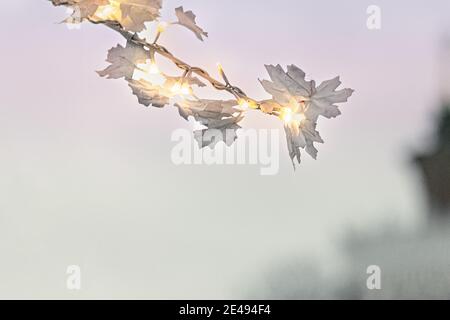 Ein Zweig eines dekorativen Baumes mit einer Girlande im Park. Weihnachtsschmuck im Park. Stockfoto