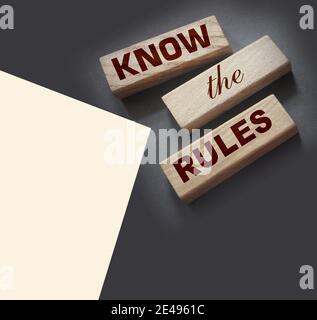 Kennen Sie die Regeln Wort auf Holzblöcke isoliert auf dunkelgrauem Hintergrund. Business-Prozess-Regulierung Konzept. Stockfoto