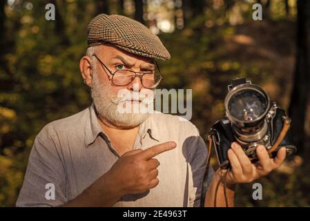 Stop oder Il Shoot. Alte Kamera Mann Punkt Finger Sommer im Freien. Fotoshooting. Reiseaufnahmen. Urlaubsfotograf einstellen. Halten Sie Erinnerungen von der Reise fest. Stockfoto
