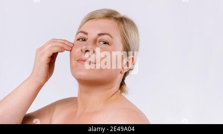 Banner, Langformat. Blonde Frau mit feuchtigkeitsspendender, sauberer und glänzender Haut auf weißem Hintergrund mit leerer Seite Werbefläche. Stockfoto