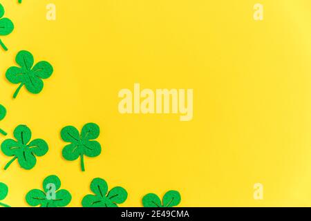 St. Patricks Day Hintergrund. Einfach minimalistisches Design mit grünem Kleeblatt. Kleeblätter isoliert auf gelbem Hintergrund. Symbol von Irland. Glück w Stockfoto