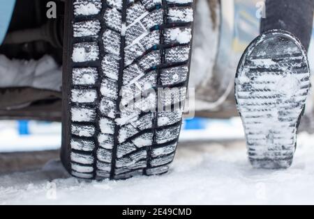 Autoreifen auf der Winterstraße sind mit Schnee bedeckt. Ein Auto auf einer verschneiten Gasse. Ein Autorad im Schnee. Stockfoto