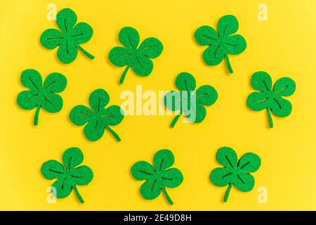 St. Patricks Day Hintergrund. Einfach minimalistisches Design mit grünem Kleeblatt. Kleeblätter isoliert auf gelbem Hintergrund. Symbol von Irland. Glück w Stockfoto