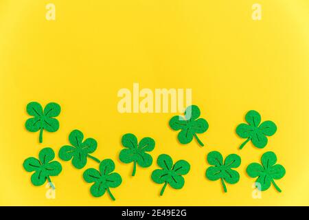 St. Patricks Day Hintergrund. Einfach minimalistisches Design mit grünem Kleeblatt. Kleeblätter isoliert auf gelbem Hintergrund. Symbol von Irland. Glück w Stockfoto