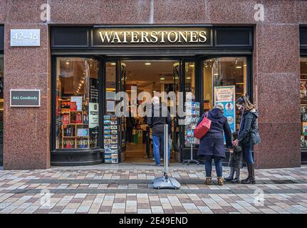 Belfast, Großbritannien. Dezember 2022. Kunden, die Gesichtsmasken tragen, stehen Schlange, um den Waterstones Bookstore zu betreten. Kredit: SOPA Images Limited/Alamy Live Nachrichten Stockfoto