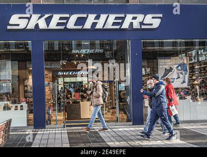 Belfast, Großbritannien. Dezember 2022. Käufer mit Gesichtsmasken kommen am Sketchers Store vorbei. Kredit: SOPA Images Limited/Alamy Live Nachrichten Stockfoto