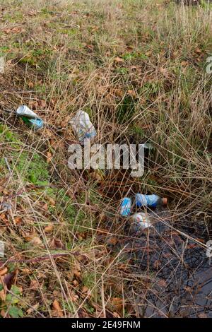 Umweltverschmutzung: Dosen und Plastikflaschen achtlos in einen Graben geworfen Stockfoto