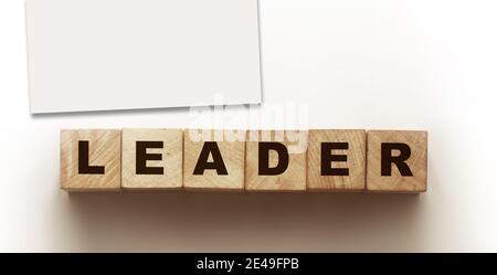 Holzwürfel mit Text Leader in schwarz auf einer Holzblockoberfläche geschrieben. Geschäftskonzept. Stockfoto