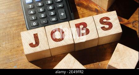 Jobs Wort mit Holzklötzen auf Schreibtisch mit Rechner gemacht. Business Karriere Arbeit HR-Konzept. Stockfoto