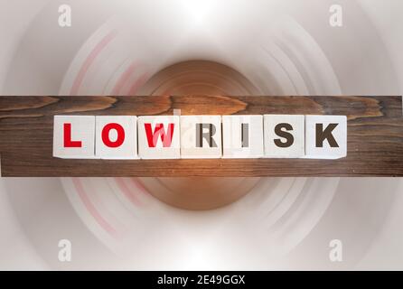 Wörter mit geringem Risiko auf Holzwürfeln geschrieben. Finanzielle Risikobewertung, Risikoprämie und Portfolio-Risikomanagement-Konzept.. Stockfoto