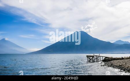 Holzsteg am Atitlan See am Strand in Panajachel, Guatemala. Mit schöner Landschaft Landschaft der Vulkane Toliman, Atitlan und San Pedro Stockfoto