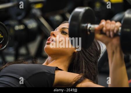 Fit Frau Bank Pressen mit Hanteln in einem Fitnessstudio Stockfoto