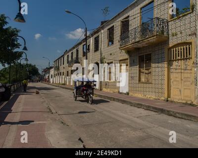 Iquitos, Peru- 14. Dezember 2017: Verfallene Kolonialhäuser mit Keramikfliesen an einer Straße in einer kleinen Stadt mitten im Amazonasdschungel, Stockfoto