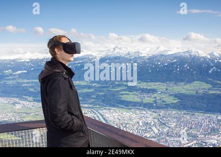 Person mit Virtual-Reality-Brille vor Bergkulisse Stockfoto