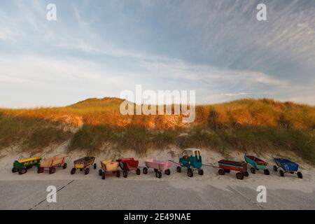 Abendstimmung mit Dünen und Kinderwagen am Strandübergang von Nebel nach Amrum in Nordfriesland, Schleswig-Holstein, Deutschland Stockfoto