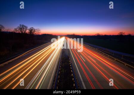 Autobahn A8 München - Salzburg Autobahn mit viel Verkehr, Langzeitbelichtung bei Sonnenuntergang, Lichtspuren von Autos, Highspeed, Bayern, Deutschland, Europa, Stockfoto