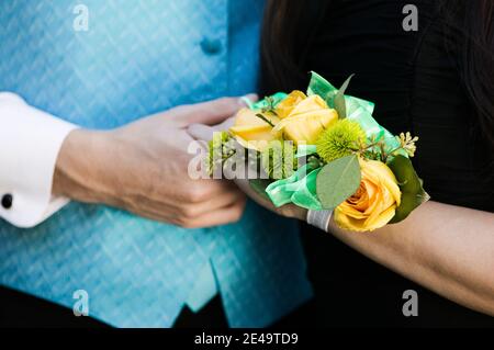 Teenage Girl trägt Corsage mit Abschlussball Datum Stockfoto