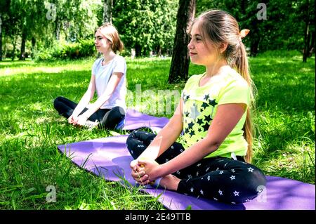 Teen Mädchen tun Yoga im Park. Schöne Mädchen teen Freund tun Yoga für gesund Stockfoto