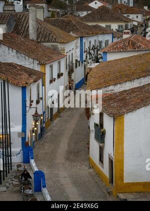 Panoramablick auf alte historische weiße Wände Häuser Gebäude schmal Kopfsteinpflaster Gasse Straße in Obidos Portugal Europa Stockfoto