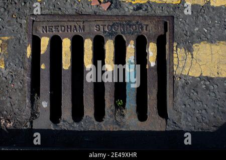 Eine Ablaufabdeckung auf einer Straße in Wirral, England. Stockfoto