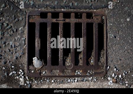 Eine Ablaufabdeckung auf einer Straße in Wirral, England. Stockfoto