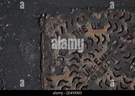 Ein Mannloch auf einer Straße in Wirral, England. Stockfoto