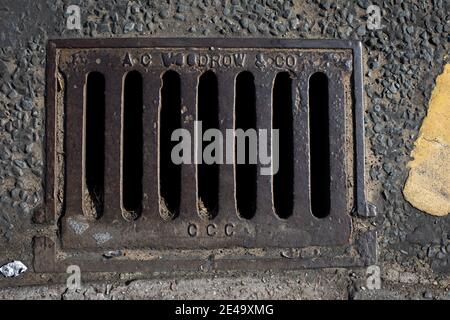 Eine Ablaufabdeckung auf einer Straße in Wirral, England. Stockfoto