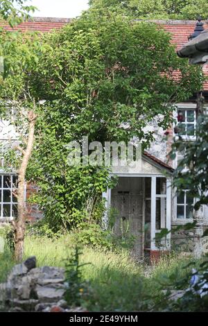 Über gewachsenem Garten und ruiniert leerstehende Hütte Stockfoto