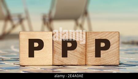 Drei Holzwürfel mit Buchstaben PPP am Meeresstrand. Geschäftskonzept. Stockfoto