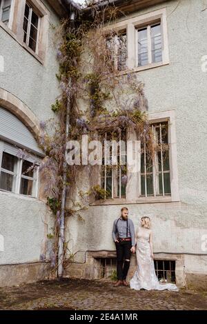 Wunderschöne Hochzeit Paar umarmt und zu Fuß in der Nähe des alten Schlosses in sonnigen schönen Park. Stilvolle schöne Braut und Bräutigam posiert auf dem Hintergrund der alten Stockfoto