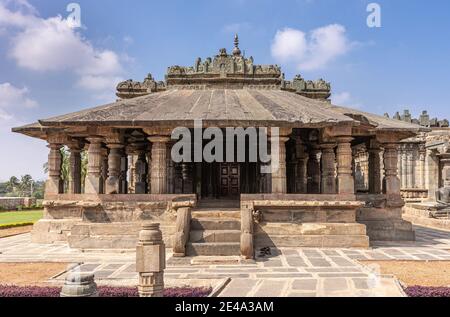 Lakkundi, Karnataka, Indien - 6. November 2013: Brauner Stein Mandapam Nahaufnahme des Brahma Jinalaya Tempels unter blauer Wolkenlandschaft. Stockfoto
