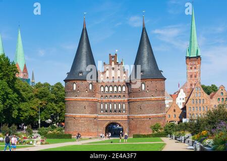 Lübeck, Holstentor von Westen in Richtung Altstadt. Links die Zwillingstürme der Marienkirche. Rechts der Turm der Petrikirche, davor das historische Salzlager, Ostsee, Schleswig-Holstein, Deutschland Stockfoto