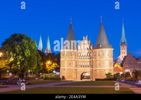 Lübeck, Holstentor von Westen in Richtung Altstadt. Links die Zwillingstürme der Marienkirche. Rechts der Turm der Petrikirche, davor das historische Salzlager, Ostsee, Schleswig-Holstein, Deutschland Stockfoto