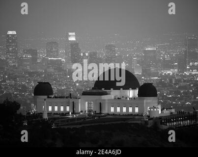 Neblige nächtliche Skyline der Innenstadt hinter Los Angeles's City-Besitz Griffith Park Observatory. Stockfoto