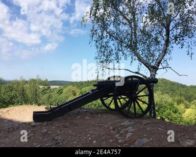 Mittelalterliche Kanone auf dem Hügel vor der Kulisse des Waldes. Stockfoto