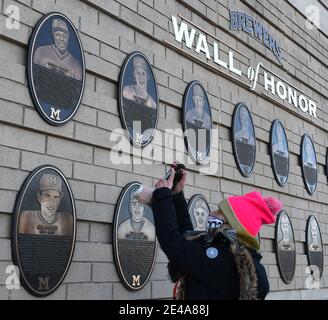 Milwaukee, Wisconsin, USA. Januar 2021. Reporter und Fans kamen zum American Family Field (bis zu diesem Jahr als Miller Park bekannt) in Milwaukee, nachdem der Baseball-große Hank Aaron am 22. Januar 2021 in Atlanta starb. Er war 86 Jahre alt. Vor dem Stadion befindet sich eine Statue von Aaron. Seine Plakette ist links oben auf der Brewers Wall of Honor vor dem Stadion zu sehen, während der Journalist MARTI GLASER sie filmt. Aaron spielte im Milwaukee County Stadium, das abgerissen wurde, als American Family Field nebenan gebaut wurde, für die Milwaukee Braves und die Milwaukee Brewers. Er war der erste Spieler, der Babe RuthÃ¢â‚¬ brach Stockfoto