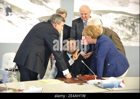 Der französische Präsident Nicolas Sarkozy spricht mit dem britischen Premierminister Gordon Brown und der deutschen Bundeskanzlerin Angela Merkel vor einem Round-Table-Gespräch mit den Führern der G8-Gruppe während ihres Gipfeltreffens in der Guardia Di Finanza Schule von Coppito in L'Aquila, Italien, am 8. Juli 2009. Foto von Elodie Gregoire/ABACAPRESS.COM Stockfoto