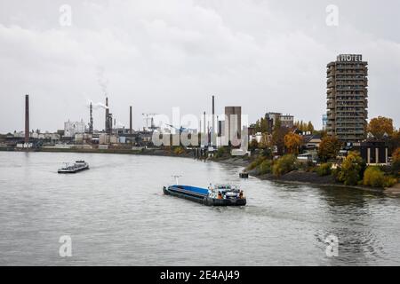 Duisburg, Ruhrgebiet, Nordrhein-Westfalen, Deutschland - Industrielandschaft, Binnenschiffe fahren auf dem Rhein vorbei am Hotel Rheingarten und den Chemiewerken im Duisburger Hafen im Stadtteil Homberg. Stockfoto