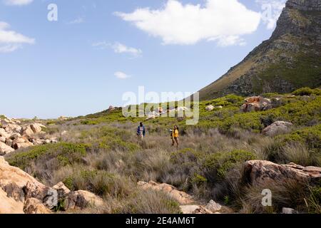 Fit afranamerikanischen Paar trägt Rucksäcke Wandern an der Küste Stockfoto