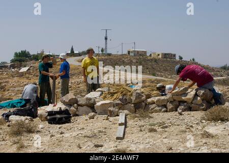 Eine jüdische Siedlerjugend stapelt Steine auf, um eine Struktur auf einem Hügel in der Nähe der israelischen Westjordansiedlung Maaleh Mikhmash in der Nähe von Ramallah zu bauen, Dienstag, 28. Juli 2009. Der israelische Ministerpräsident Benjamin Netanjahu und der US-amerikanische Friedensbeauftragte George Mitchell versuchen, einen öffentlichen Streit über jüdische Siedlungen im Westjordanland zu lösen. Foto von Olivier Fitoussi /ABACAPRESS.COM Stockfoto