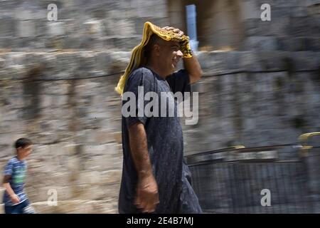 Ein Palästinenser trägt seinen Gebetsdecke auf dem Kopf, um Schatten zu spenden, während er am 28. August 2009 zum Haram el-Sharif (dem Heiligen Heiligtum) und zur al-Aqsa-Moschee in der Jerusalemer Altstadt, Israel, geht. Auf seinem Weg zu den ersten Freitagsgebeten des heiligen Monats Ramadan. Muslime auf der ganzen Welt feiern den heiligen Monat Ramadan, wo die Beobachter fasten von Sonnenaufgang bis Sonnenuntergang. Foto von Olivier Fitoussi/ABACAPRESS.COM Stockfoto