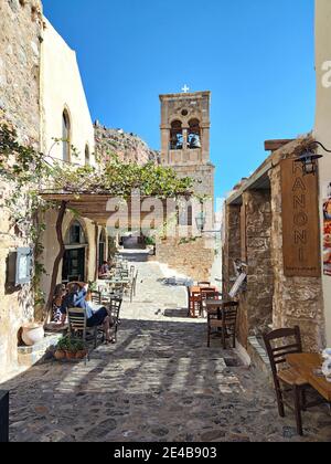 Eine schmale Gasse führt zu einem freistehenden Glockenturm in der Unterstadt Monemvasia, Corona Times, Laconia, Peloponnes, Griechenland Stockfoto