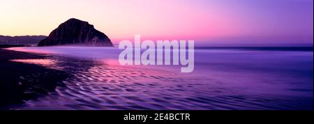 Blick auf den Strand bei Sonnenaufgang, Morro Rock, Morro Bay, San Luis Obispo County, Kalifornien, USA Stockfoto