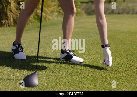 Niedriger Abschnitt der kaukasischen Frau Golf spielen Ball vor Machen Sie einen Schuss Stockfoto