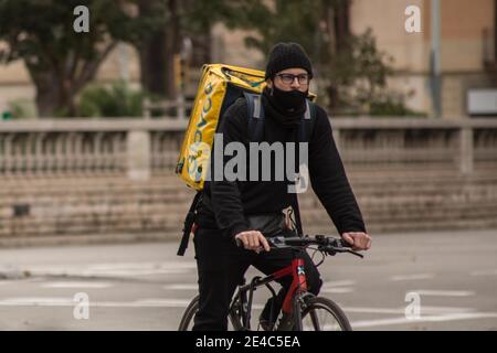 Barcelona, Katalonien, Spanien. Januar 2021. Glovo App Delivery man gesehen Fahrrad fahren.das Ministerium für Arbeit von Spanien entwickelt einen gesetzlichen Rahmen, der die Tätigkeit von Home Delivery Menschen umfasst, bekannt als Fahrer, die für digitale Plattformen wie Glovo, Deliveroo, Just Eat oder Uber Eats arbeiten. Das neue Rider-Gesetz würde Unternehmen verpflichten, ihre Arbeiter einzustellen und damit die Zahl der falschen Selbstständigen zu beenden. Quelle: Thiago Prudencio/DAX/ZUMA Wire/Alamy Live News Stockfoto